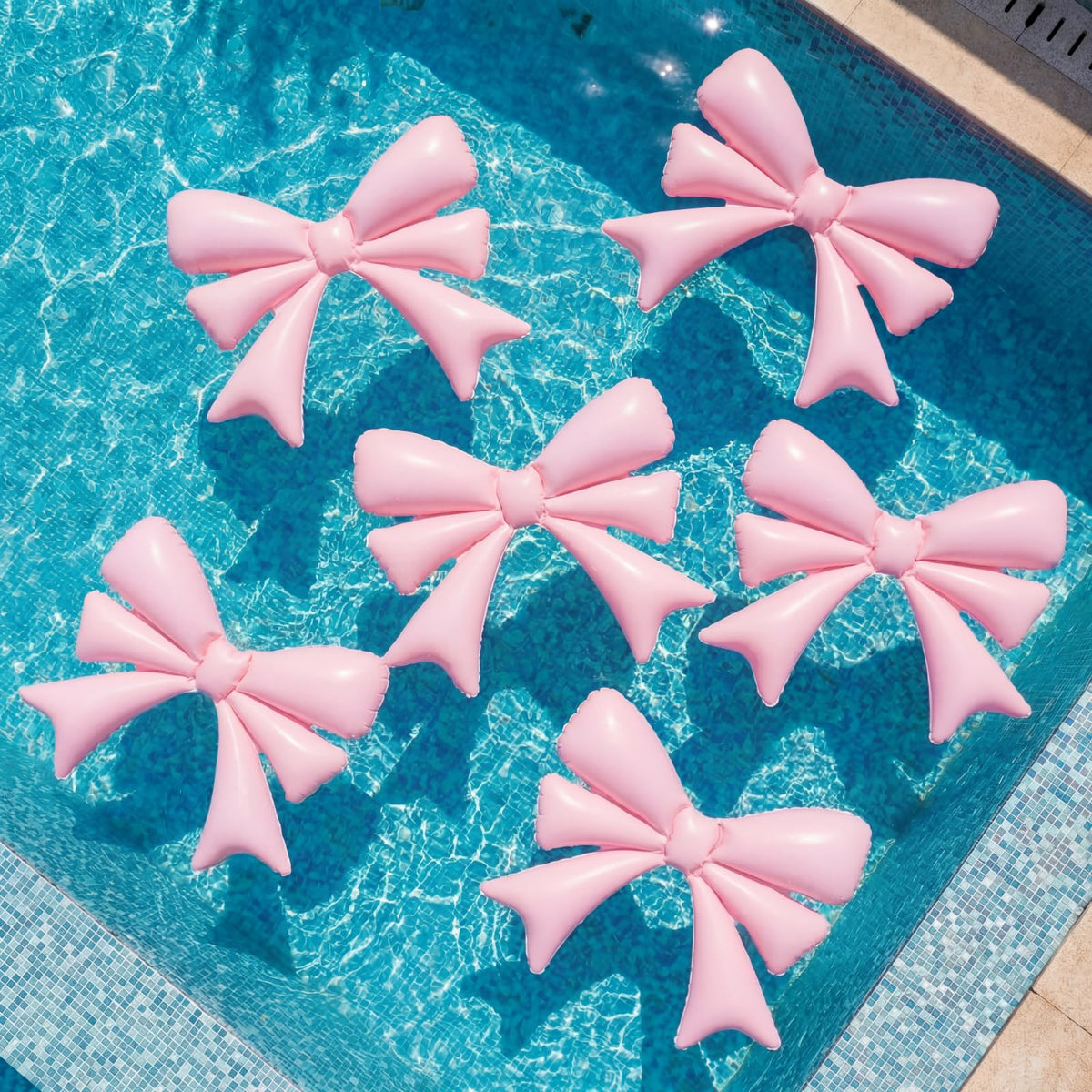 Teyva Daily pink bow pool float inflated for an adult pool party.