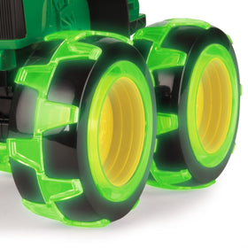 TOMY Monster Treads Lightning Wheels John Deere Tractor side view, motion-activated lights enhance play.