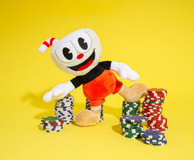 Toynk Cuphead 8-inch plush sitting on bed demonstrates ready-to-display desk companion.