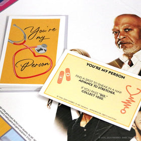 USAOPOLY Grey's Anatomy token scrub top adds familiar flair to gameplay.