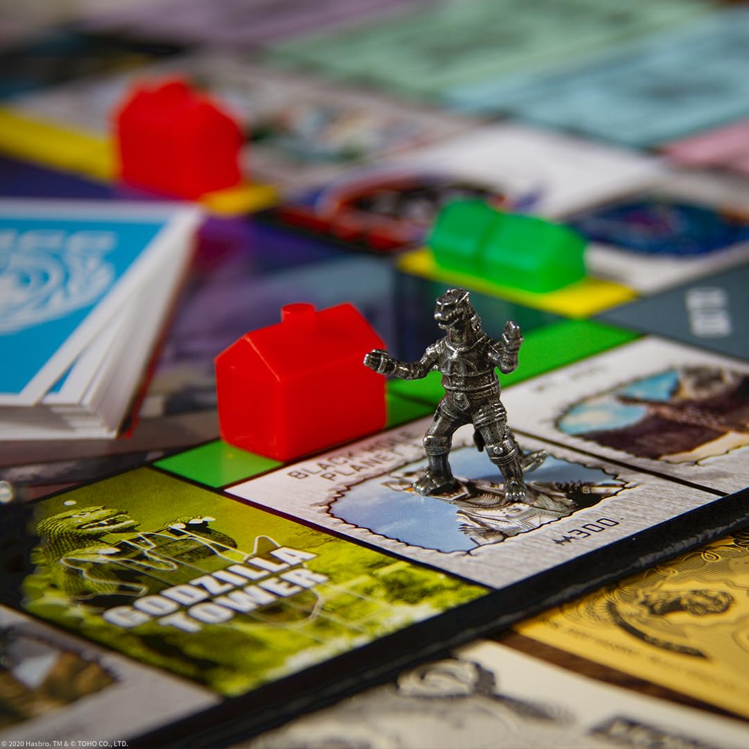 USAOPOLY Godzilla game components showing renamed FACILITIES and BASES for themed play