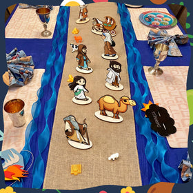 Vicenpal Passover set Moses model complements blue gauze and linen runner.