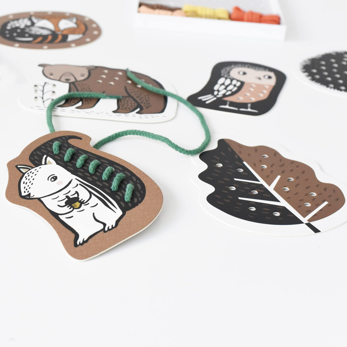 Wee Gallery Woodland Lacing Cards used as a travel activity for kids.