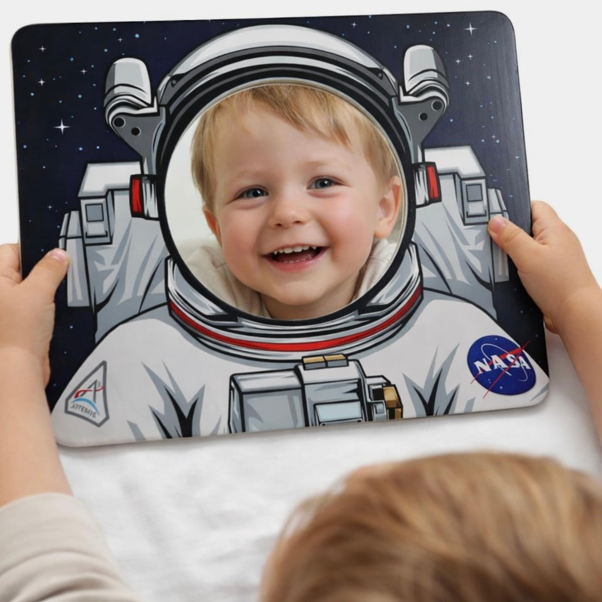 Young Supporters toddler holds the mirror for on-the-go playtime.